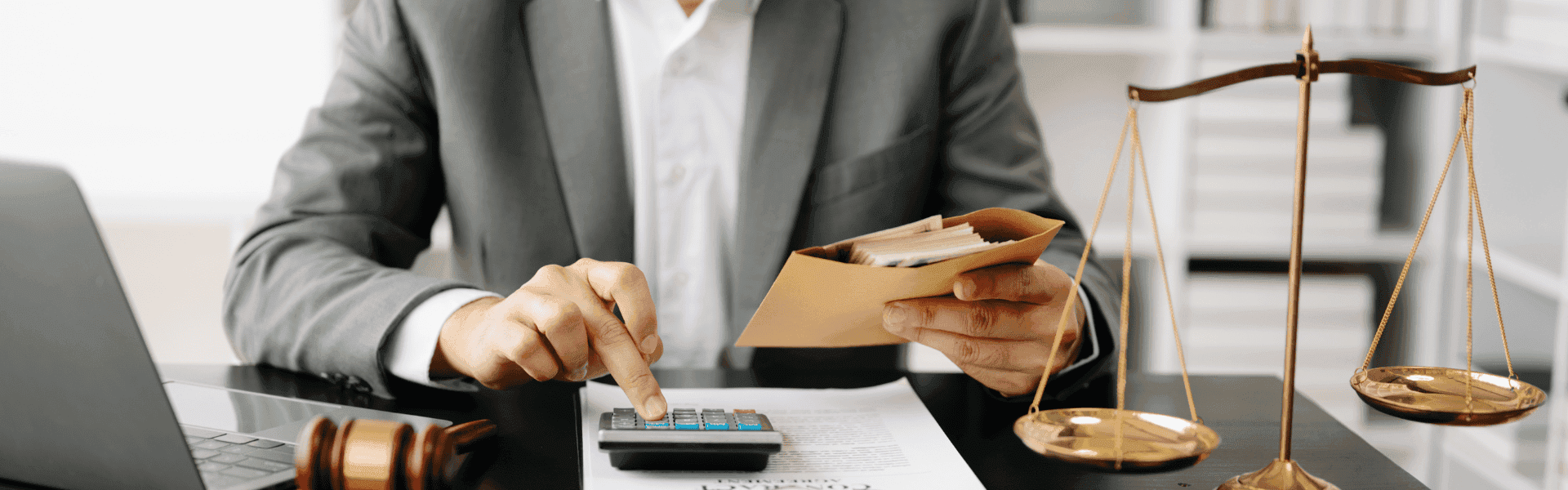 Ein Geschäftsmann tippt auf einen Taschenrechner und hält einen Umschlag mit Geld. Daneben eine Waage der Gerechtigkeit und ein Richterhammer – Symbol für Recht, Finanzen oder Steuerberatung.