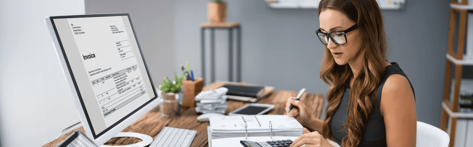 Bürokauffrau sitzt am Schreibtisch und rechnet
