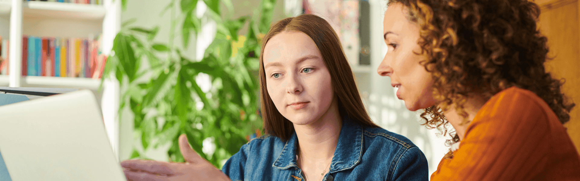 Junge Frau im Gespräch mit einer Mentorin am Laptop – Entscheidung zwischen Studium oder Ausbildung. Beratung und Zukunftsplanung für den Karrierestart.