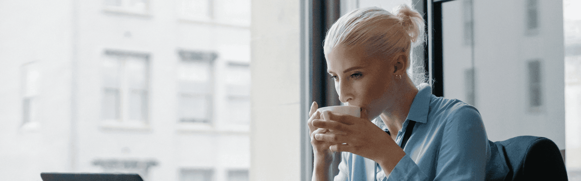 Gehalt eines Betriebswirts in der Steuerbranche – Nachdenkliche Fachkraft mit Kaffee am Laptop. Verdienstmöglichkeiten und Karrierechancen für Betriebswirte im Steuer- und Finanzwesen.